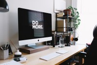 Desk with an Apple computer with the words "Do More" on the screen