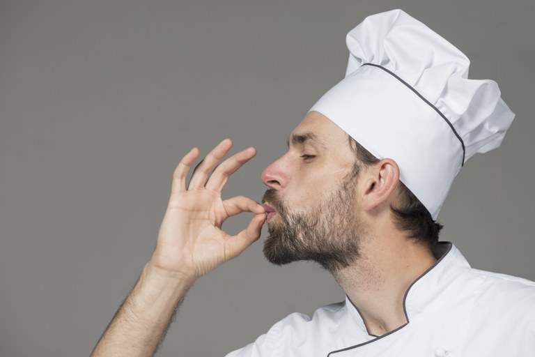 male-chef-white-uniform-making-tasty-sign-against-gray-background.jpg